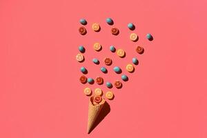 A variety of delicious sweets explode from the waffle cone, view from above. From left to the right direction photo
