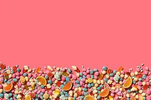 Various sweets, candys are palced on the photo on the coral background