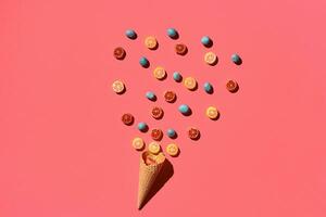 A variety of delicious sweets explode from the waffle cone, view from above. From left to the right direction photo