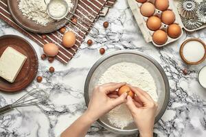 Close-up shot. Top view of a baker cook place, hands are working with a raw dough on the marble table background. photo