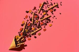 A variety of delicious sweets explode from the waffle cone, view from above. From left to the right direction photo