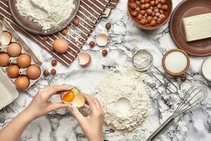 Close-up shot. Top view of a baker cook place, hands are working with a raw dough on the marble table background. photo