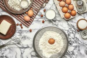 Close-up shot. Top view of a baking ingredients and kitchenware on the marble table background. photo