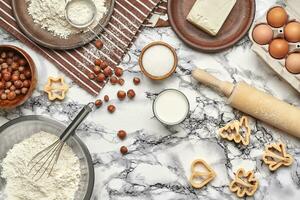 Close-up shot. Top view of a baking ingredients and kitchenware on the marble table background. photo