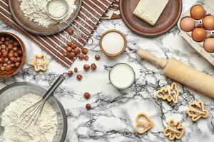 Close-up shot. Top view of a baking ingredients and kitchenware on the marble table background. photo