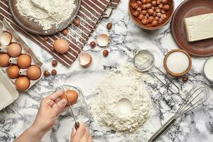 Close-up shot. Top view of a baker cook place, hands are working with a raw dough on the marble table background. photo