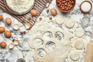 Close-up shot. Top view of a baking ingredients and kitchenware on the marble table background. photo