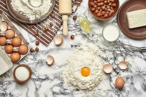 de cerca disparo. parte superior ver de un horneando ingredientes y batería de cocina en el mármol mesa antecedentes. foto