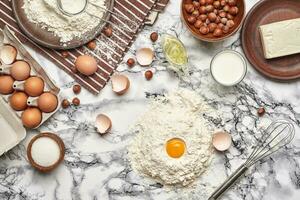 de cerca disparo. parte superior ver de un horneando ingredientes y batería de cocina en el mármol mesa antecedentes. foto