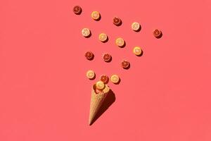 A variety of delicious sweets explode from the waffle cone, view from above. From left to the right direction photo