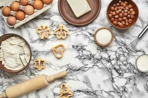 Close-up shot. Top view of a baking ingredients and kitchenware on the marble table background. photo