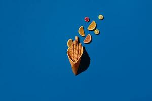 Wafer rolls and marmalade from waffle cone on blue background photo