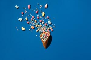 An image of a heap of dragee sweets that is sprinkled from a waffle cone photo