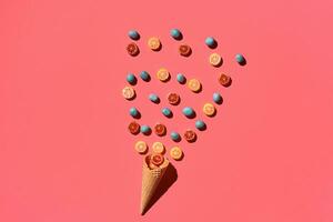 A variety of delicious sweets explode from the waffle cone, view from above. From left to the right direction photo