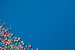 Photo of candies dragee placed on the corner of image with a copy space in the middle