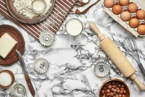 Close-up shot. Top view of a baking ingredients and kitchenware on the marble table background. photo