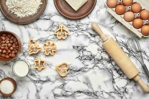 Close-up shot. Top view of a baking ingredients and kitchenware on the marble table background. photo