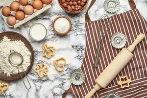 Close-up shot. Top view of a baking ingredients and kitchenware on the marble table background. photo