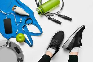 Sport woman sitting and resting after workout or exercise in fitness gym with protein shake or drinking water on floor. Relax concept. Flat lay photo