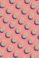 Food design with tasty pink glazed donut on peach pastel background top view pattern photo