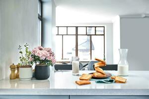 A glass of milk and toast on a table, kitchen background. photo