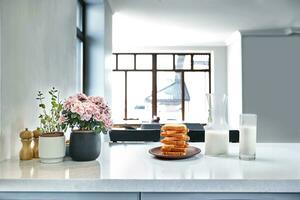 A glass of milk and toast on a table, kitchen background. photo