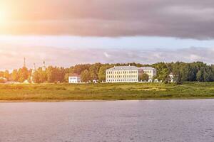 Scenic view of a old manor house by a river. Sun flare photo