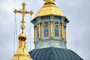 Eastern orthodox crosses on gold domes, cupolas, against blue sky with clouds photo