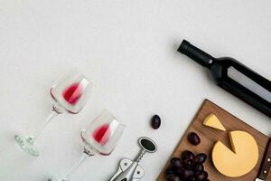 Wine, glasses and corkscrew over white background. Top view photo