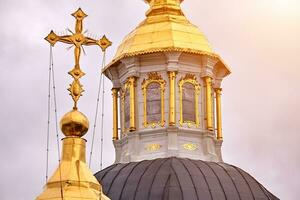 Eastern orthodox crosses on gold domes, cupolas, against blue sky with clouds photo