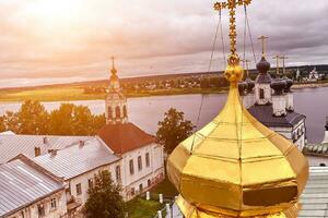 Eastern orthodox crosses on gold domes, cupolas, against blue sky with clouds photo