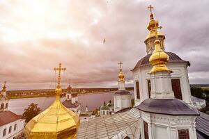 Eastern orthodox crosses on gold domes, cupolas, against blue sky with clouds photo