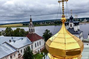 Eastern orthodox crosses on gold domes, cupolas, against blue sky with clouds photo