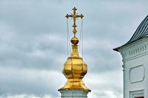 Eastern orthodox crosses on gold domes, cupolas, against blue sky with clouds photo