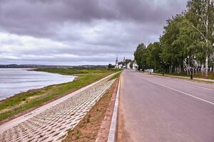 City river embankment in summer scene. River in summer view church. photo