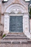 antiguo puerta de un desgastado bloqueado casa fachada o frente en azul y gris. foto