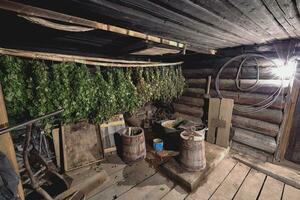 Dried herbs and branches on wooden background of ancient bathhouse photo