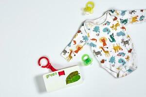 Baby care accessories and clothing on white background, top view photo