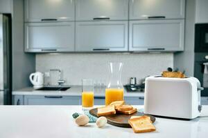 Portion of toasts on a wooden board with orange juice. Breakfast is served on a table with light blue napkin. photo