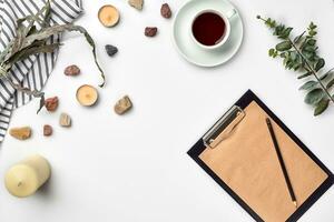 Blank opened notebook with cup of coffee on white table. Top view. Writing concept photo