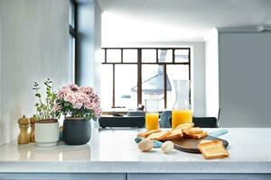 Portion of toasts on a wooden board with orange juice. Breakfast is served on a table with light blue napkin. photo