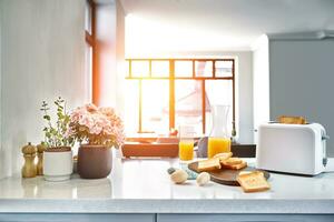 Portion of toasts on a wooden board with orange juice. Breakfast is served on a table with light blue napkin. photo