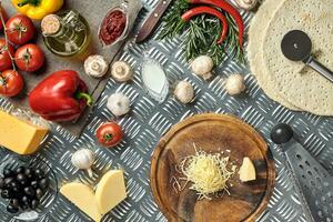 Cheese, different vegetables on metal table. Ingredients for traditional italian pizza. photo