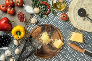 Cheese, different vegetables on metal table. Ingredients for traditional italian pizza. photo