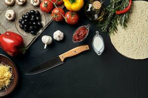 Pizza cooking ingredients. Dough, vegetables and spices. Top view with copy space photo