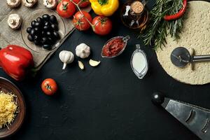 Pizza cooking ingredients. Dough, vegetables and spices. Top view with copy space photo