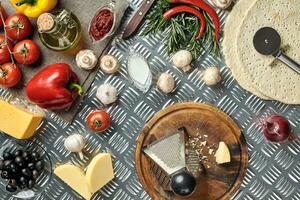 Cheese, different vegetables on metal table. Ingredients for traditional italian pizza. photo