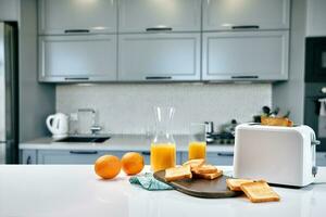 Portion of toasts on a wooden board with orange juice. Breakfast is served on a table with light blue napkin. photo