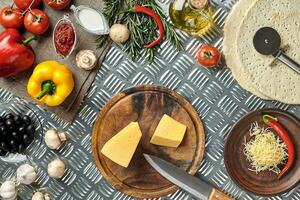 Cheese, different vegetables on metal table. Ingredients for traditional italian pizza. photo