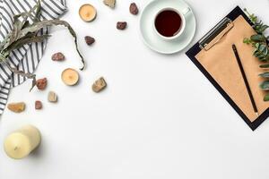 Blank opened notebook with cup of coffee on white table. Top view. Writing concept photo